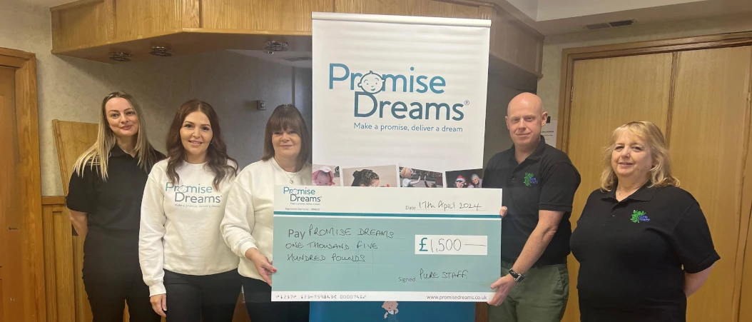 A banner image of the Pure Staff foundation team donating to Promise Dreams charity.